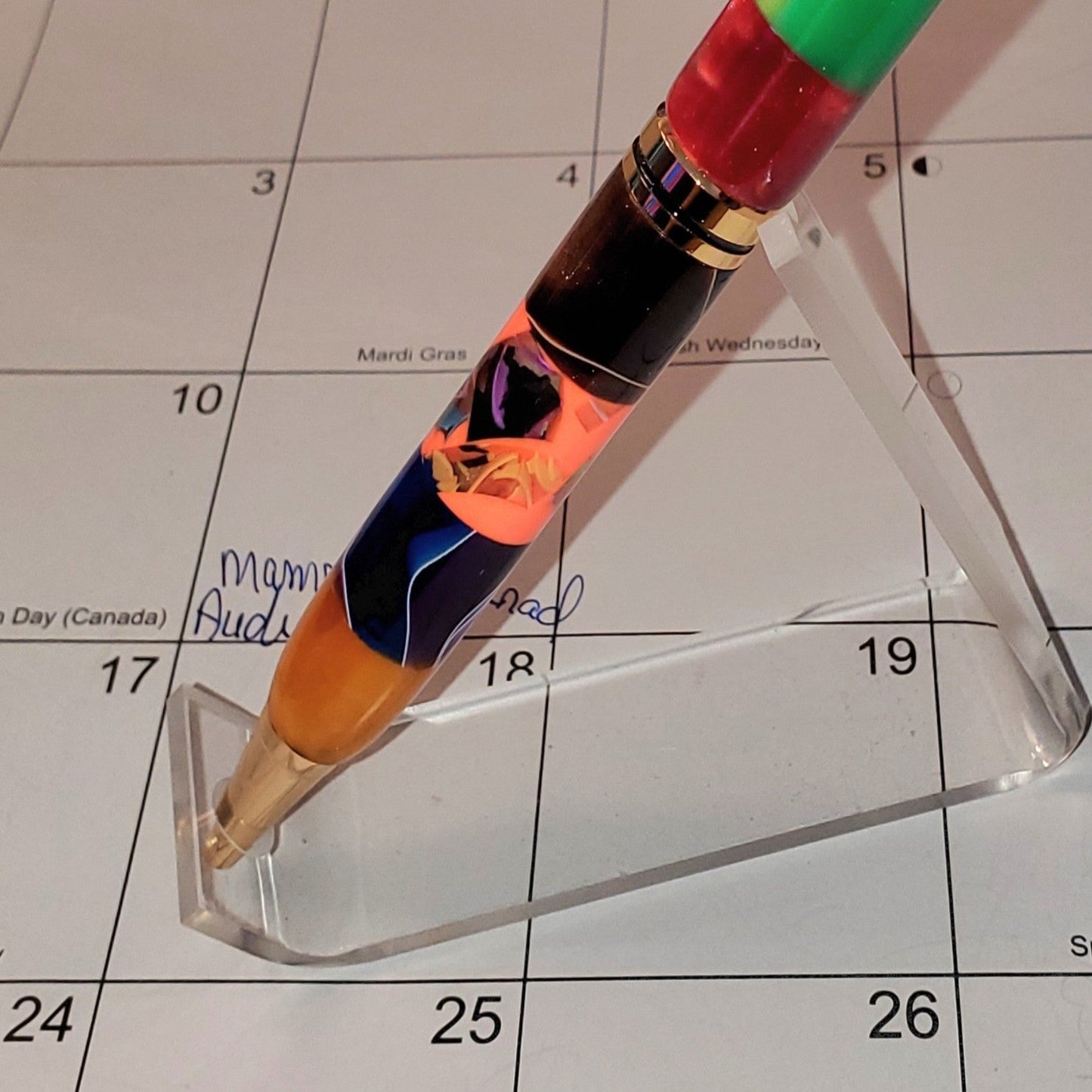close-up of the bottom half of the potpourri pen featuring a gold center band and various colors