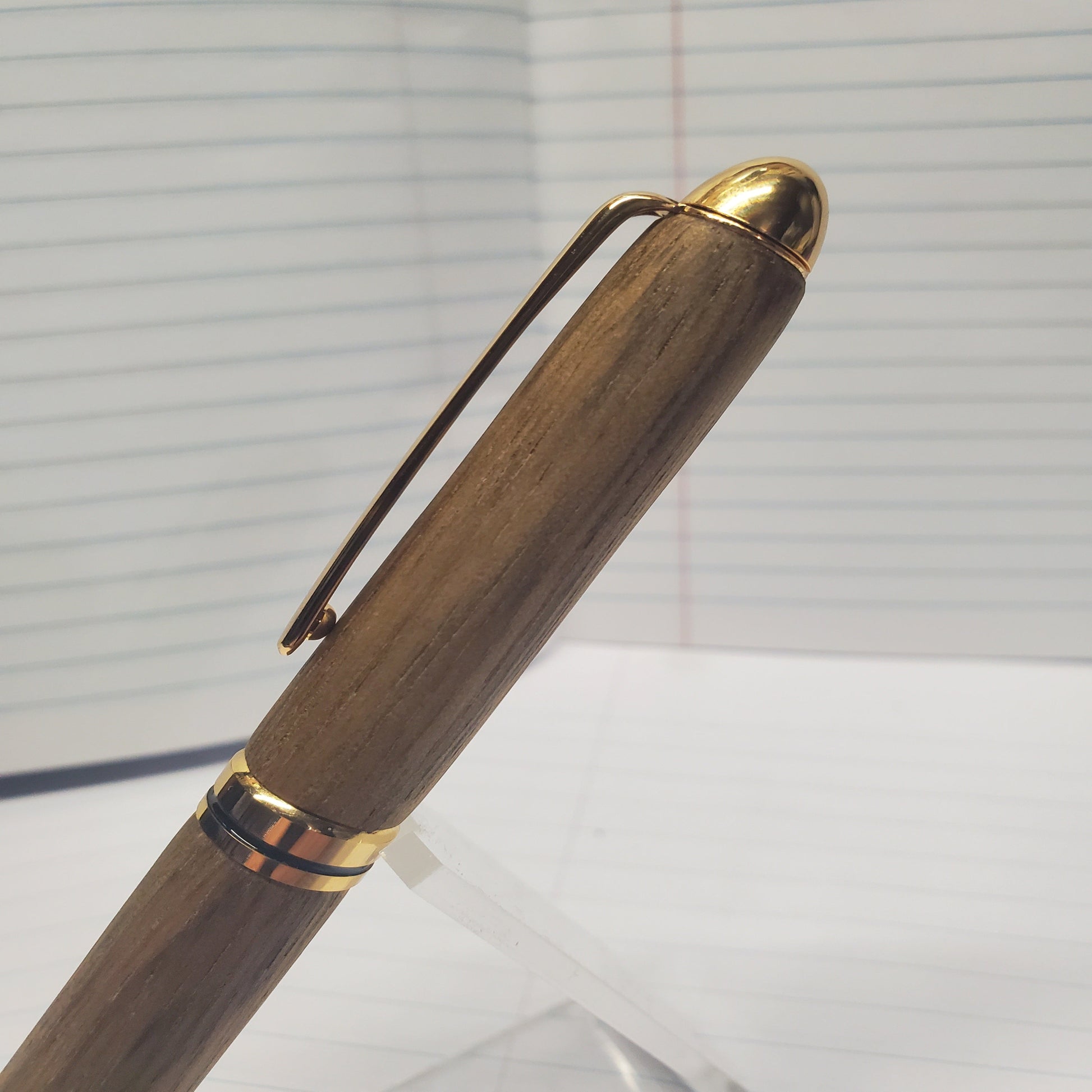 Upper half of Black Limba writing pen, showing cap, clip and woodgrain
