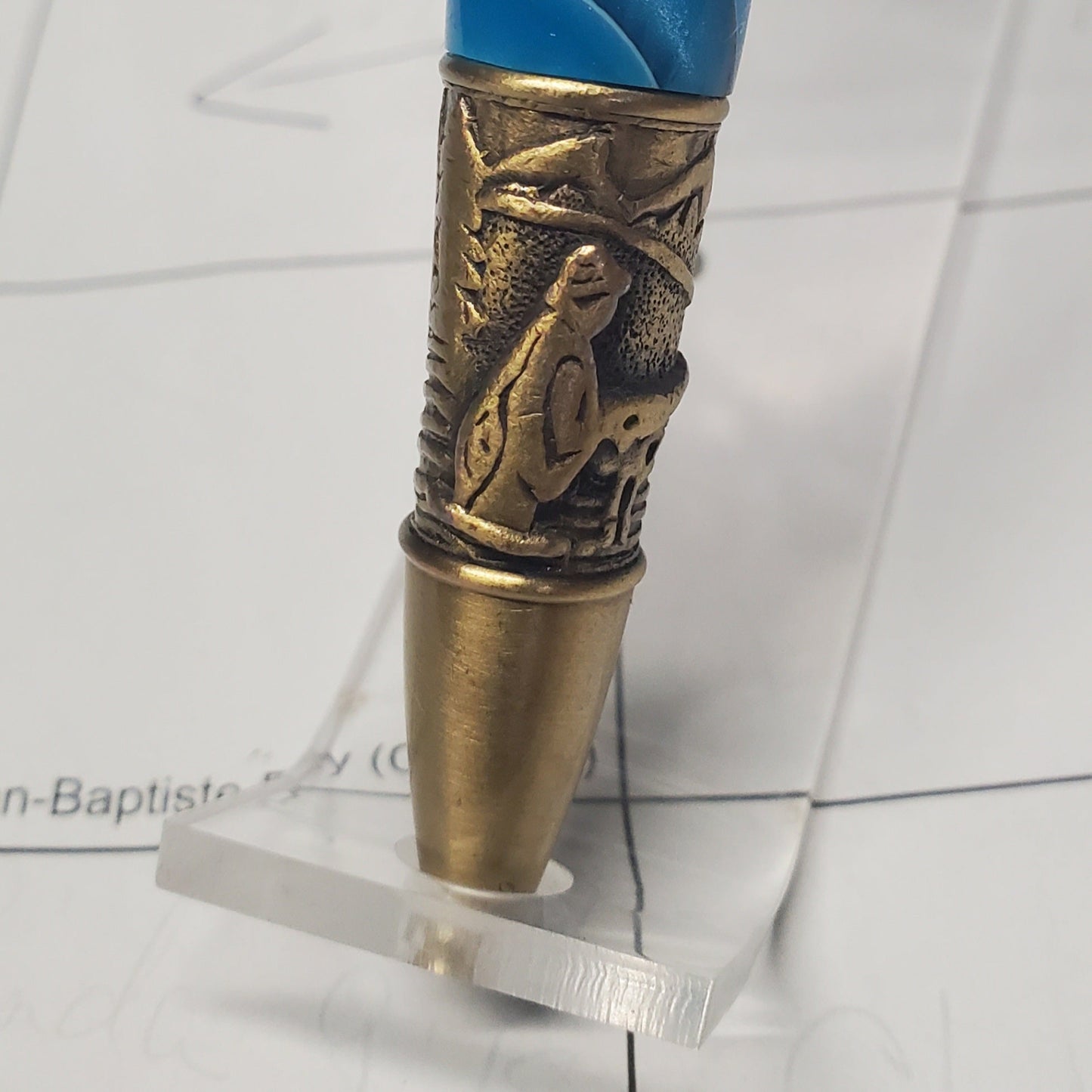 closeup of the tip of the flyfishing pen featuring engraving of a fisherman