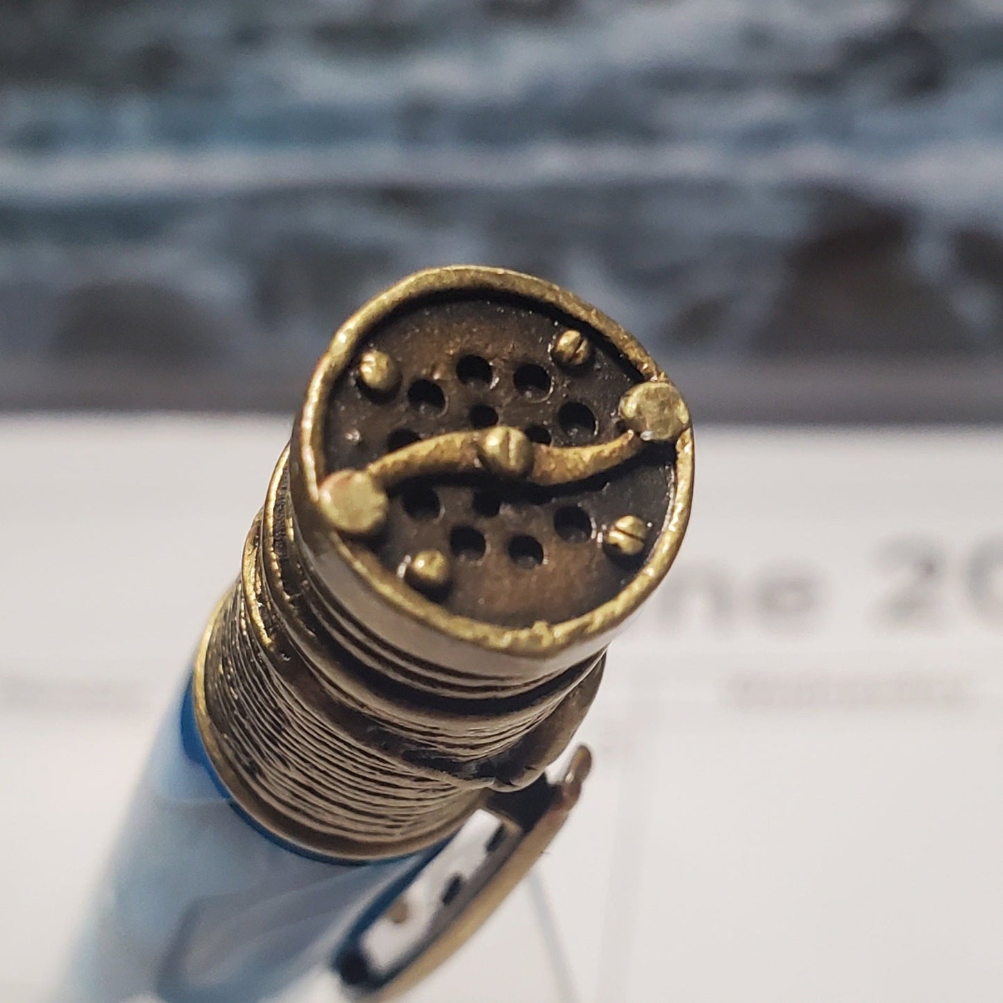 Close-up of the cap of the pen designed to look like a fishing reel