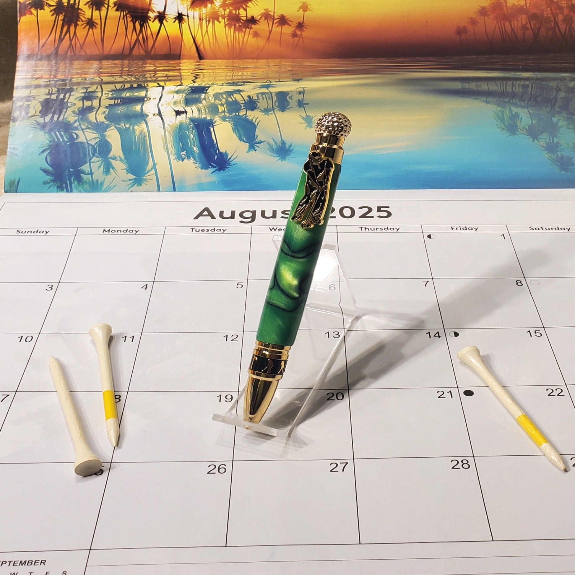 Golf writing pen featuring a green acrylic material and gold settings