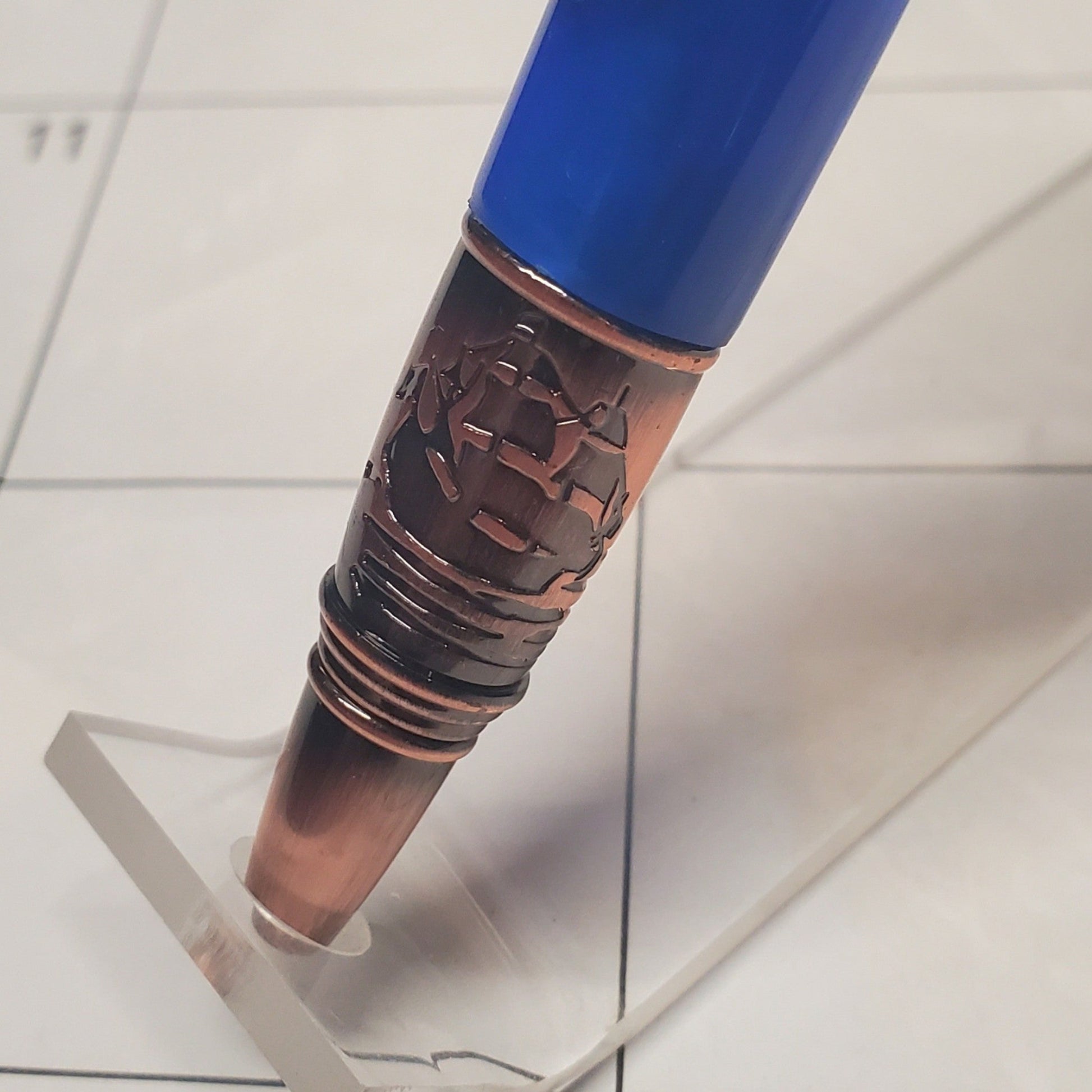 Close-up of the tip of the lighthouse pen featuring an engraving of a ship